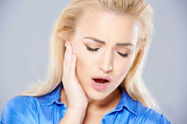 Woman with TMJ disorder experiencing jaw pain