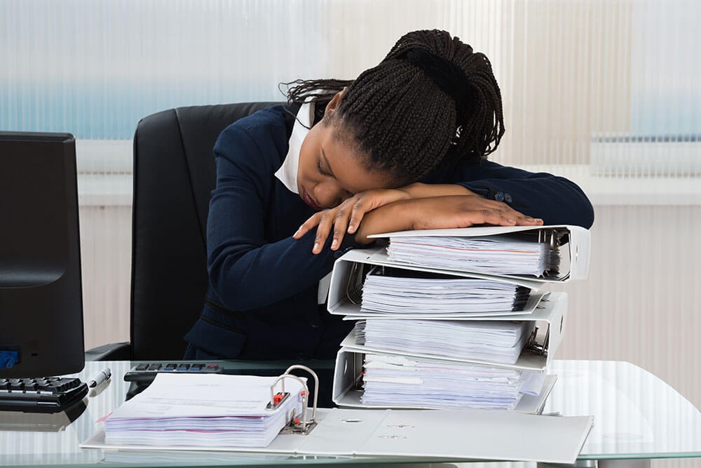 Tired businesswoman asleep at her desk